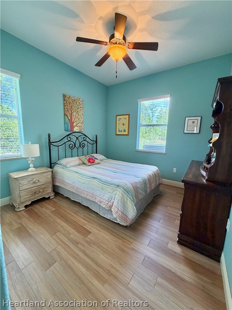 6032 Elm Road Sebring, FL 33875 - Photo 22 of 47 a bedroom with a bed and a chandelier