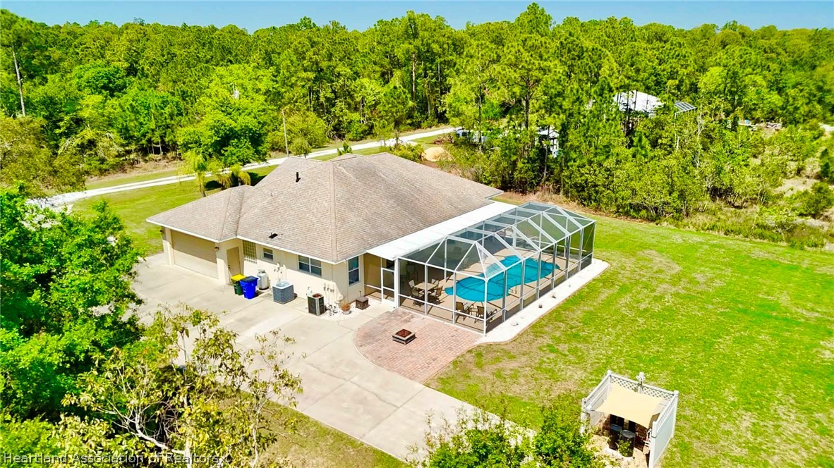 6032 Elm Road Sebring, FL 33875 - Photo 38 of 47 an aerial view of a house with swimming pool and large trees