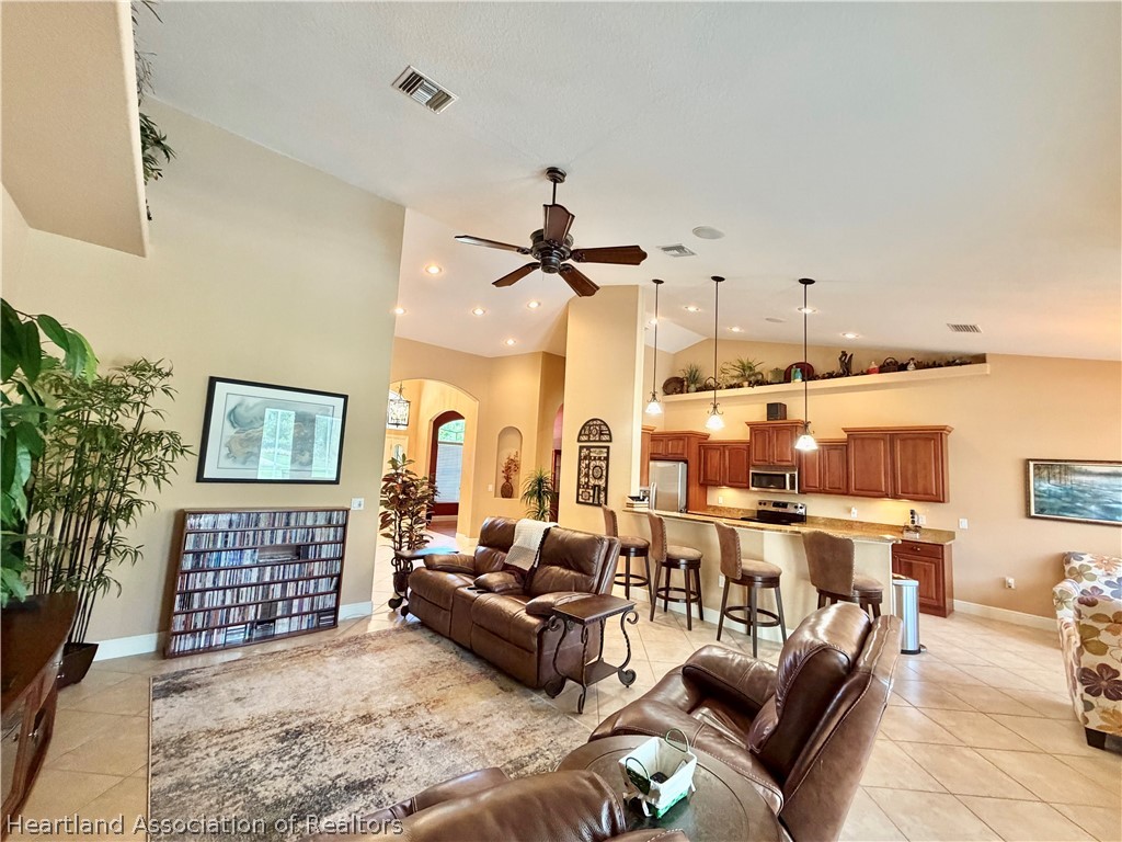 6032 Elm Road Sebring, FL 33875 - Photo 6 of 47 a living room with furniture a rug and a chandelier