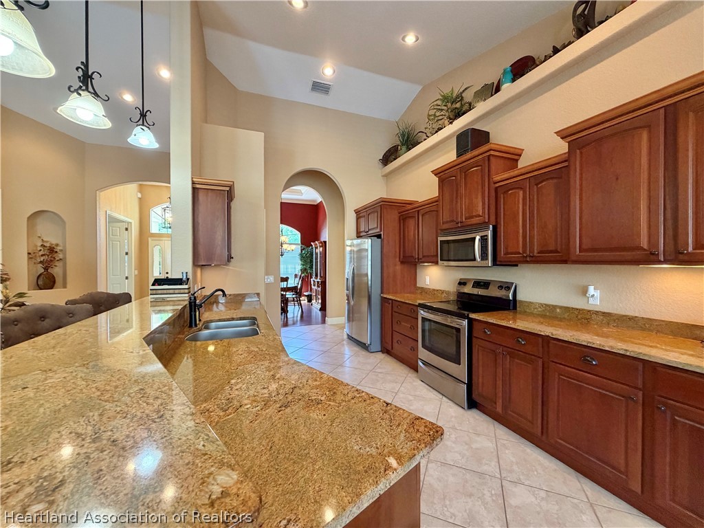 6032 Elm Road Sebring, FL 33875 - Photo 8 of 47 a kitchen with stainless steel appliances granite countertop a sink dishwasher stove and refrigerator with wooden floor