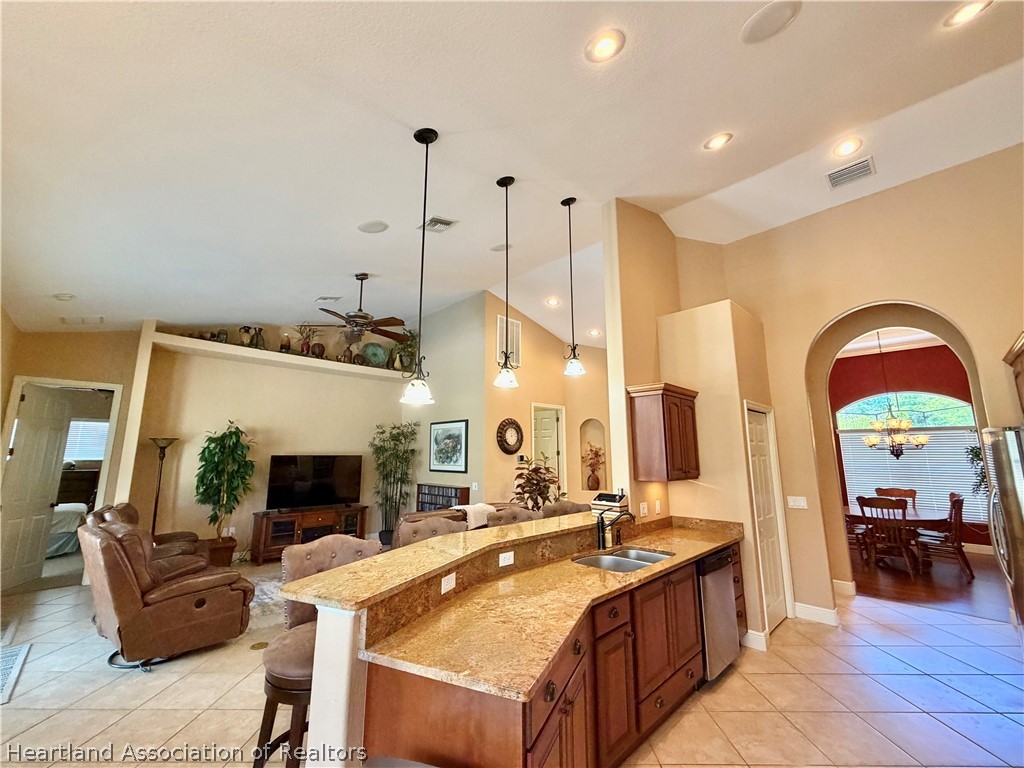 6032 Elm Road Sebring, FL 33875 - Photo 9 of 47 a large kitchen with stainless steel appliances granite countertop a stove a sink and a dining table with the view