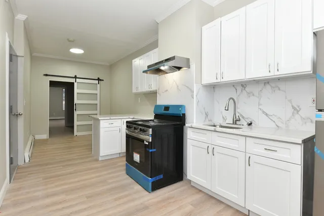 a kitchen with granite countertop white cabinets and stainless steel appliances