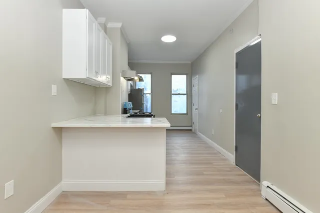 a kitchen with stainless steel appliances a sink cabinets and a wooden floor