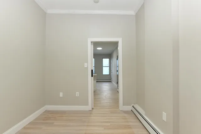 a view of a hallway with wooden floor