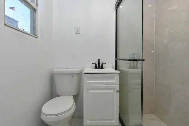 a bathroom with a toilet a sink and mirror