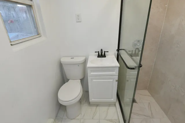 a white toilet sitting next to a small bathroom