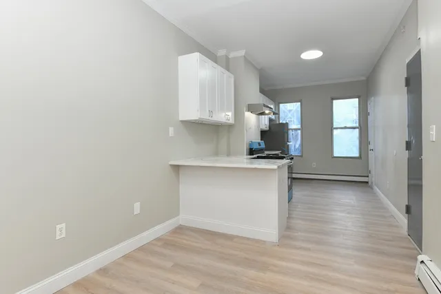 a view of kitchen with wooden floor and electronic appliances
