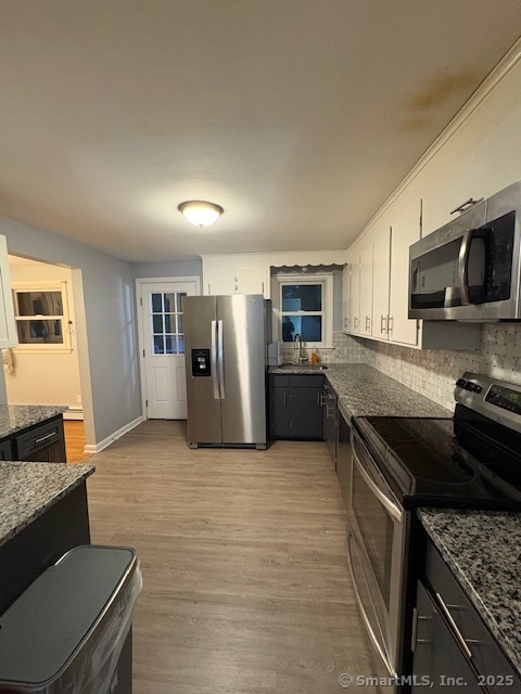 26 Lamphere Road Waterford, CT 06385 - Photo 2 of 14 a kitchen with stainless steel appliances granite countertop a stove top oven a sink a refrigerator white cabinets and wooden floor