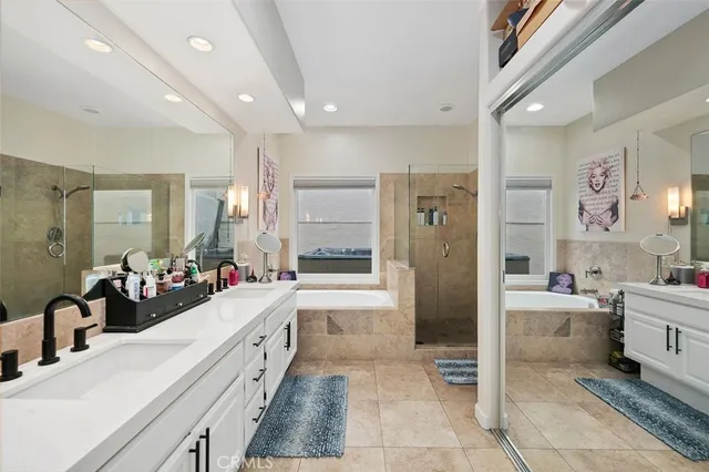 a large bathroom with a double vanity sink a large mirror and shower