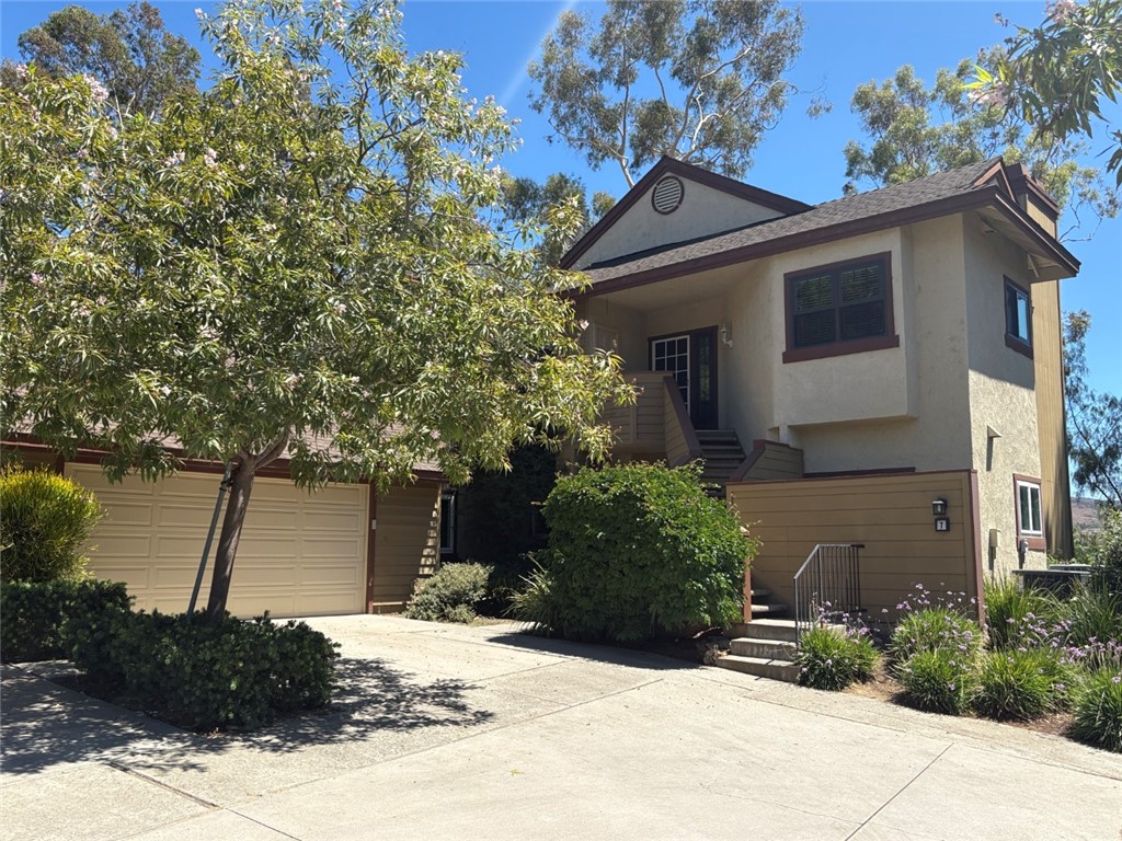 7 Rainbow, Unit 4 Irvine, CA 92603 - Photo 1 of 31 a front view of a house with a yard and garage