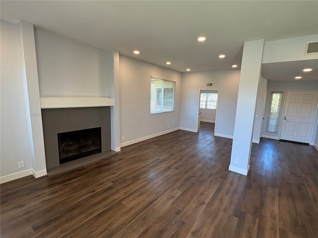 7 Rainbow, Unit 4 Irvine, CA 92603 - Photo 13 of 31 a view of an empty room with wooden floor fireplace and a window