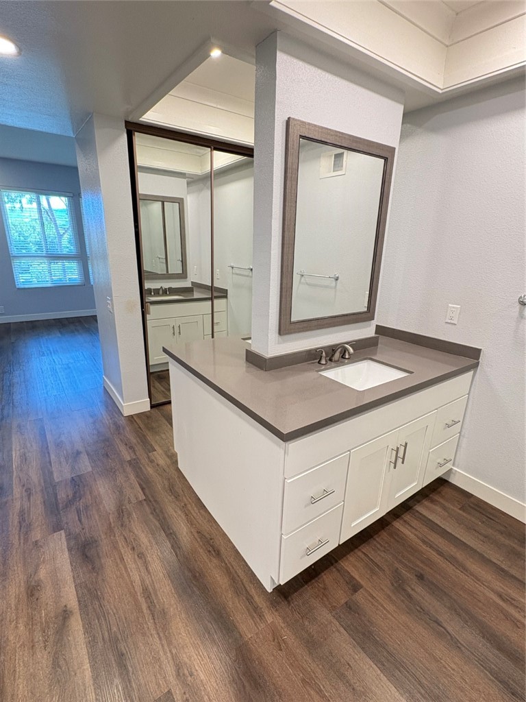 7 Rainbow, Unit 4 Irvine, CA 92603 - Photo 18 of 31 a bathroom with a sink a mirror and wooden floor