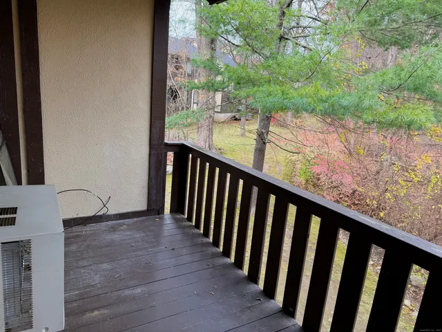 a view of a balcony with wooden floor and fence