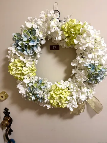 a close up of a white vase with white and yellow flowers
