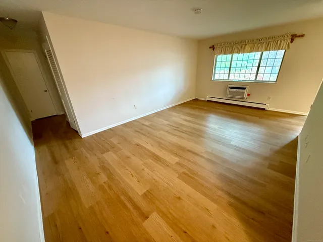 a view of a room with wooden floor and a window