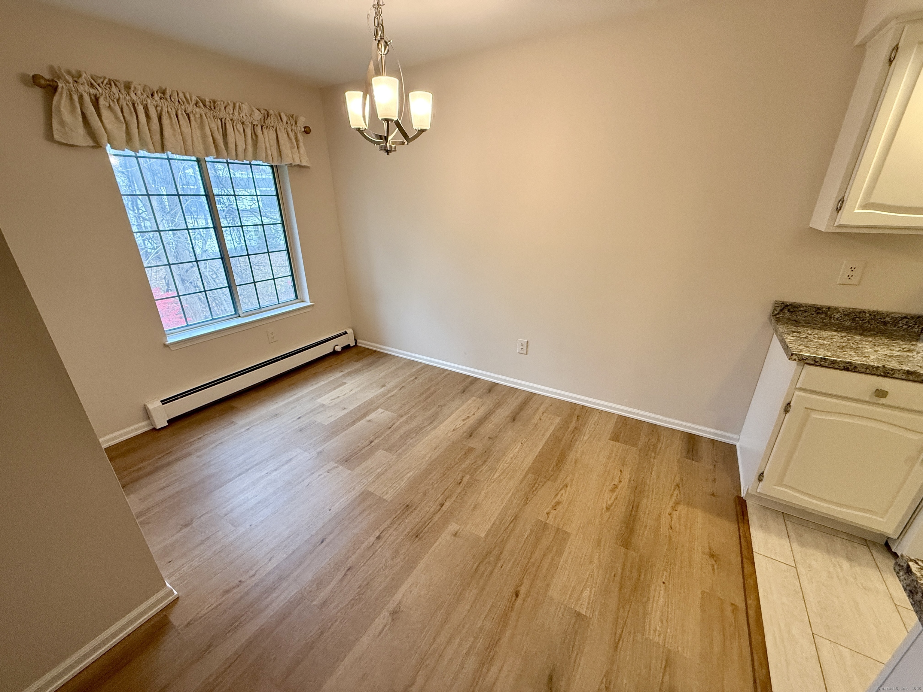 17 Rollingwood Drive, Unit 17 Brookfield, CT 06804 - Photo 7 of 13 wooden floor in an empty room with a window
