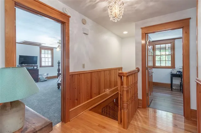 a backyard of a house with table and chairs a barbeque with potted plants and large trees