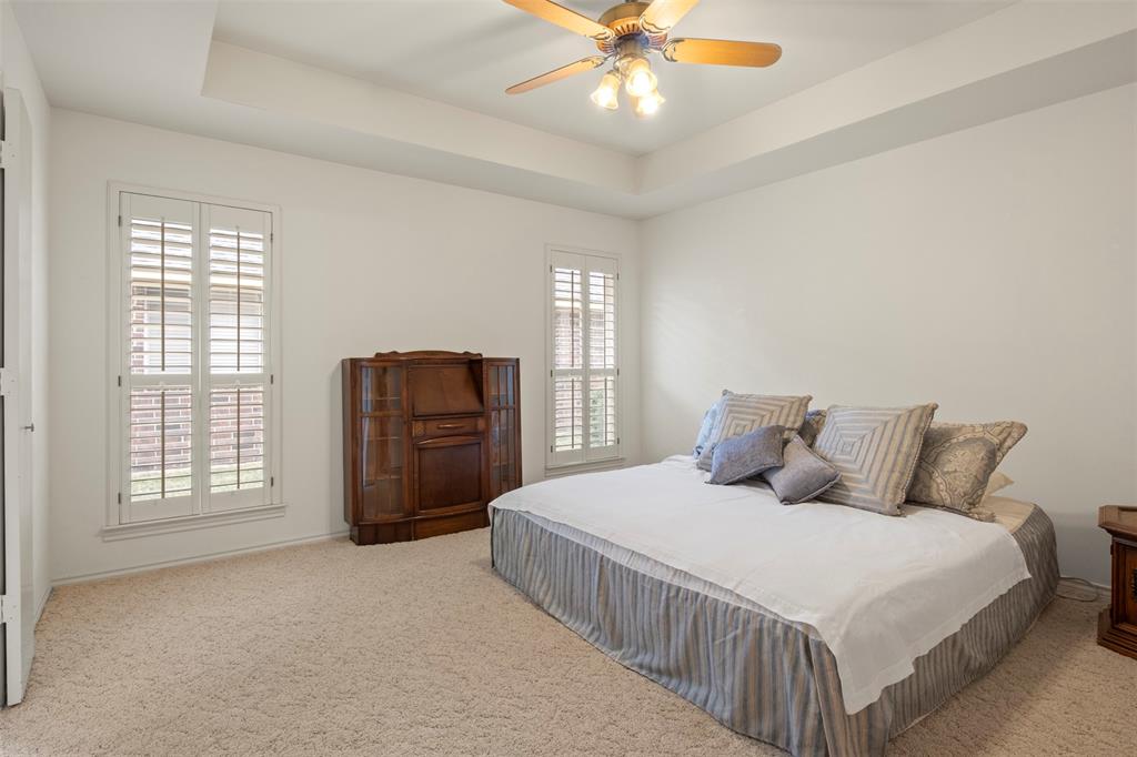 1104 Timberbend Trail Allen, TX 75002 - Photo 16 of 32 a bedroom with a bed a dresser and a chandelier
