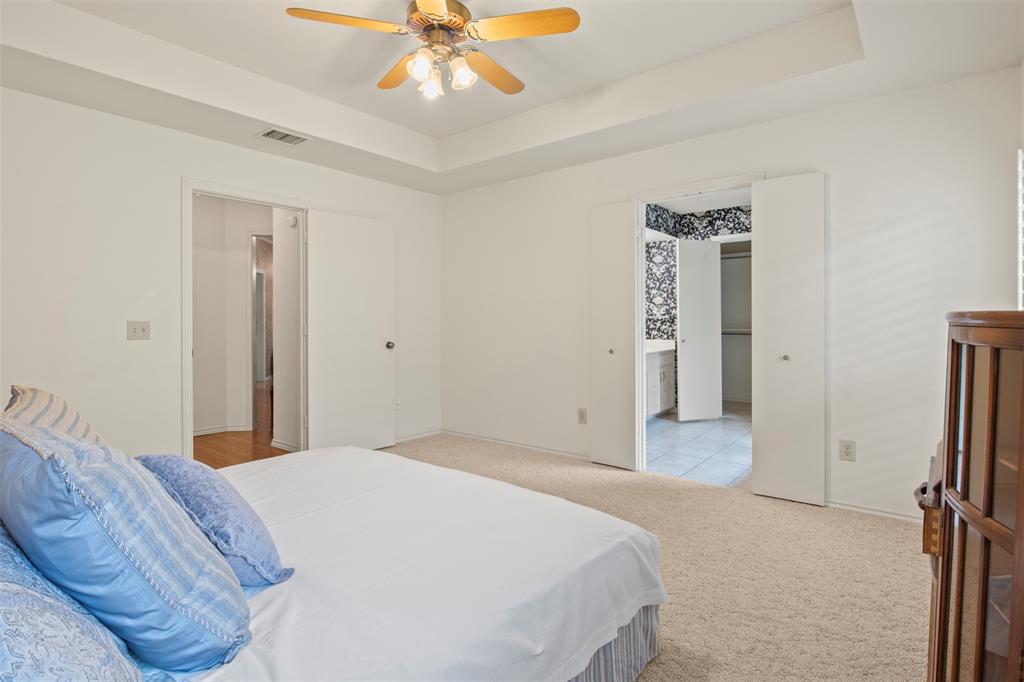 1104 Timberbend Trail Allen, TX 75002 - Photo 17 of 32 a bedroom with a bed and a chandelier