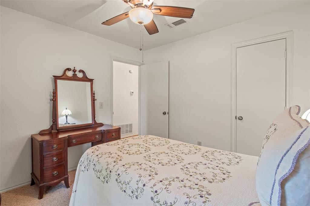 1104 Timberbend Trail Allen, TX 75002 - Photo 22 of 32 a bedroom with a bed and a chandelier
