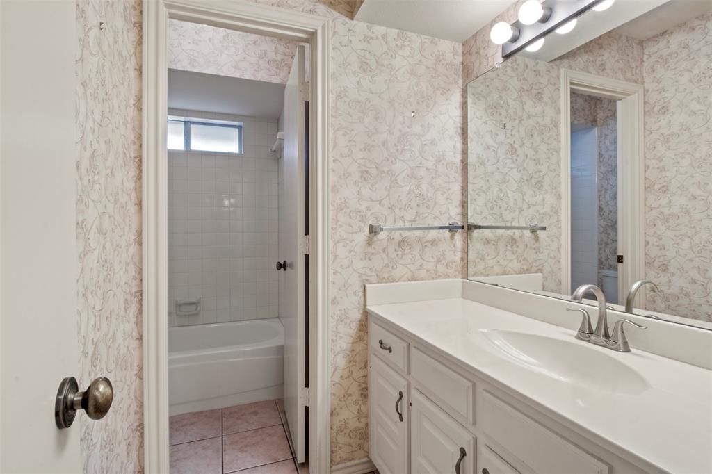 1104 Timberbend Trail Allen, TX 75002 - Photo 23 of 32 a bathroom with a sink a mirror and a bathtub
