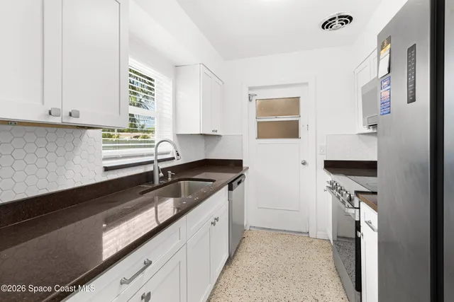 a kitchen with a sink dishwasher a stove and a refrigerator