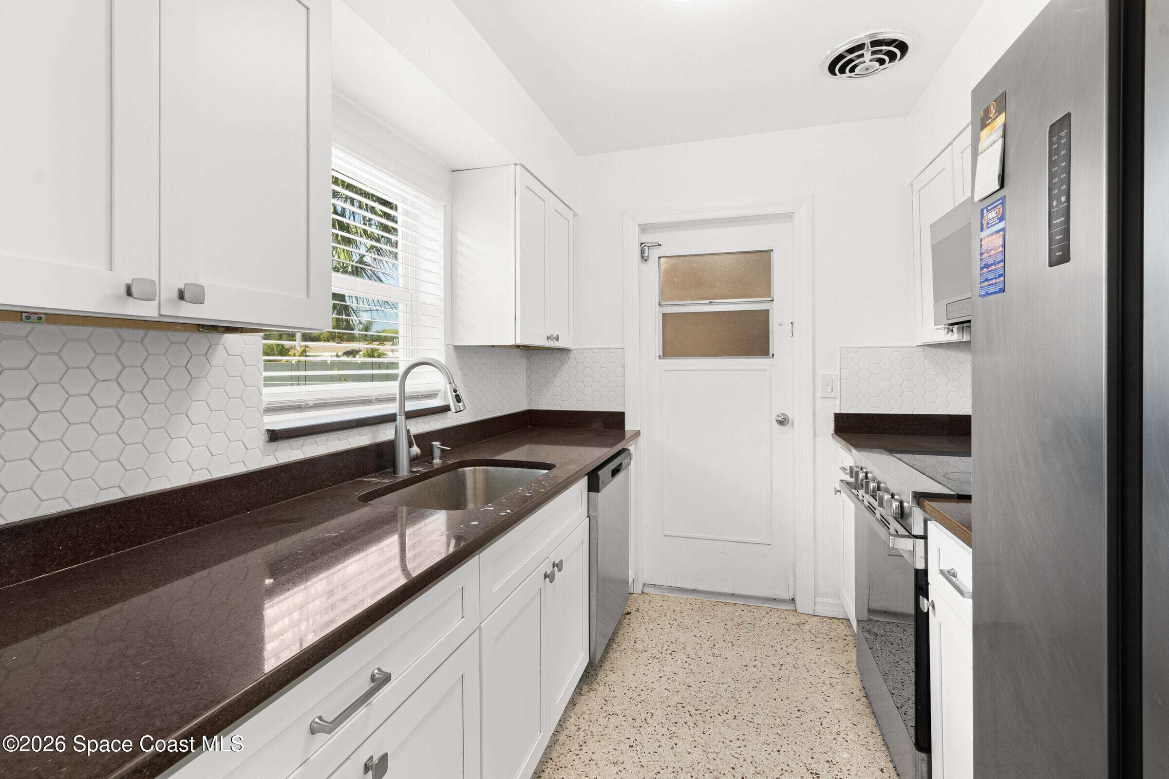 407 Bunker Street Melbourne, FL 32901 - Photo 9 of 20 a kitchen with a sink dishwasher a stove and a refrigerator