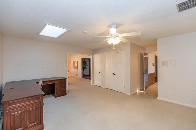a living room with furniture and a ceiling fan