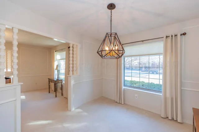 an empty room with windows and ceiling fan