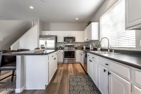 a kitchen with kitchen island granite countertop lots of counter top space a sink and appliances
