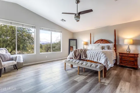 a spacious bedroom with a bed and wooden floor