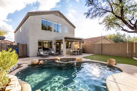 a view of house with yard and outdoor seating