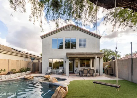a view of a patio with table and chairs potted plants and a large tree
