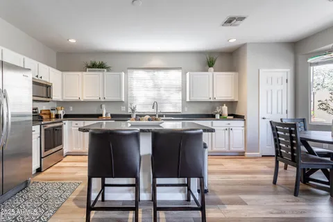 a large kitchen with granite countertop lots of counter top space and stainless steel appliances