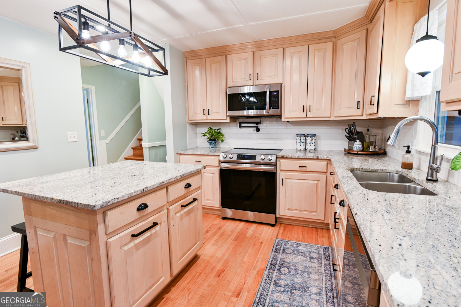 93 Deerfield Road Covington, GA 30014 - Photo 18 of 78 a kitchen with stainless steel appliances granite countertop a stove top oven a sink dishwasher and a microwave oven with white cabinets