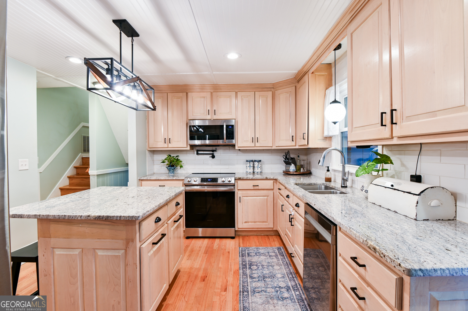 93 Deerfield Road Covington, GA 30014 - Photo 19 of 78 a kitchen with stainless steel appliances granite countertop a sink a stove top oven a counter space and cabinets