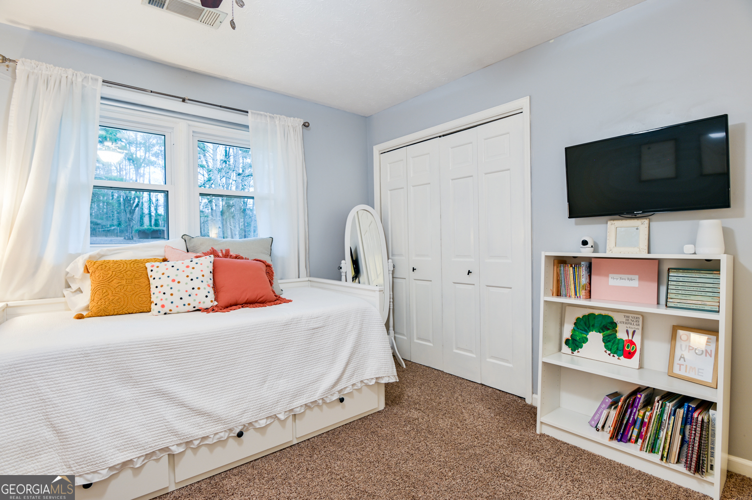 93 Deerfield Road Covington, GA 30014 - Photo 31 of 78 a bedroom with a bed a flat screen tv and a window