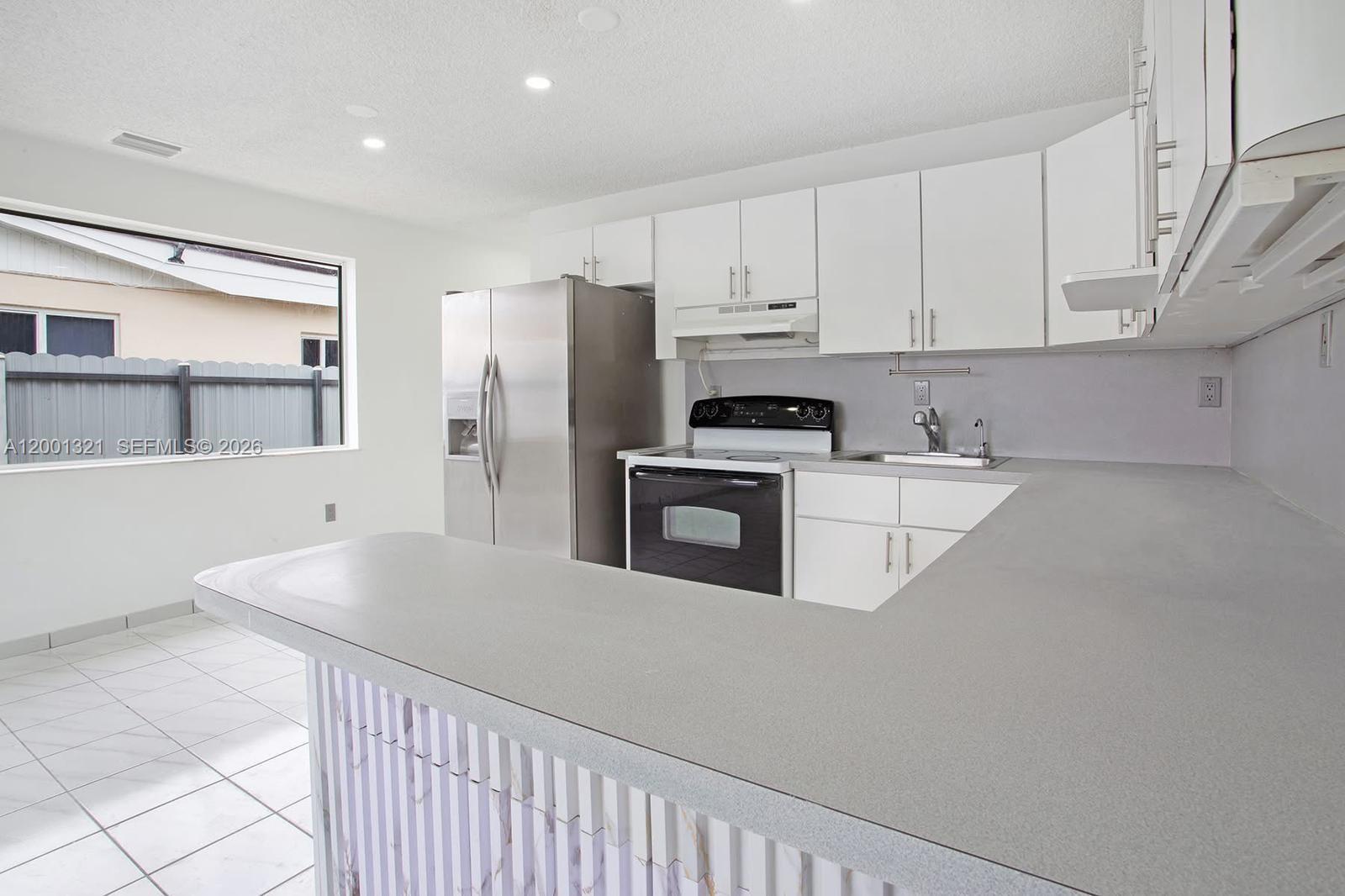 11511 Southwest 180th Street Miami, FL 33157 - Photo 5 of 22 a kitchen with white cabinets and stainless steel appliances