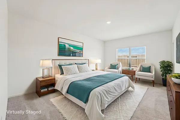 a spacious bedroom with a bed a couch and potted plant