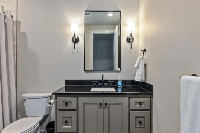 a bathroom with a toilet sink and mirror