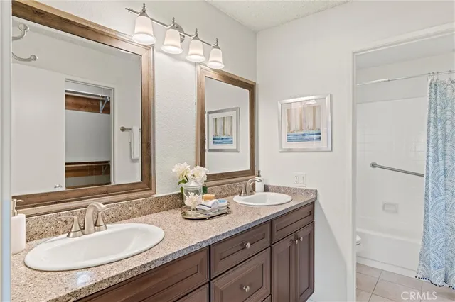 a bathroom with a granite countertop sink a mirror and a shower