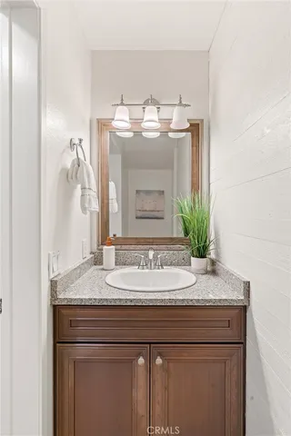 a bathroom with a granite countertop sink and a mirror