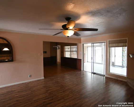 a view of an empty room with window and wooden floor