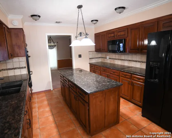 a kitchen with stainless steel appliances granite countertop a stove and a wooden cabinets