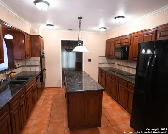 a kitchen with stainless steel appliances granite countertop a sink a stove and a refrigerator