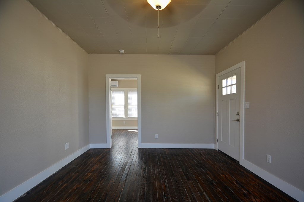 309 Lowry Street Kerrville, TX 78028 - Photo 11 of 29 a view of an empty room with wooden floor and a window