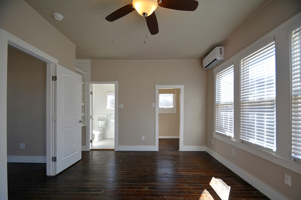 309 Lowry Street Kerrville, TX 78028 - Photo 13 of 29 a view of an empty room with wooden floor and a window