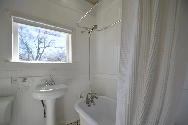a bathroom with a sink a window and a shower