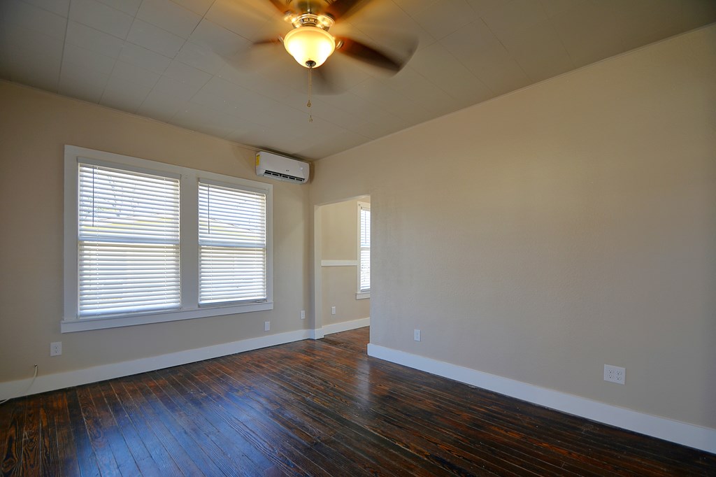 309 Lowry Street Kerrville, TX 78028 - Photo 3 of 29 an empty room with wooden floor and windows