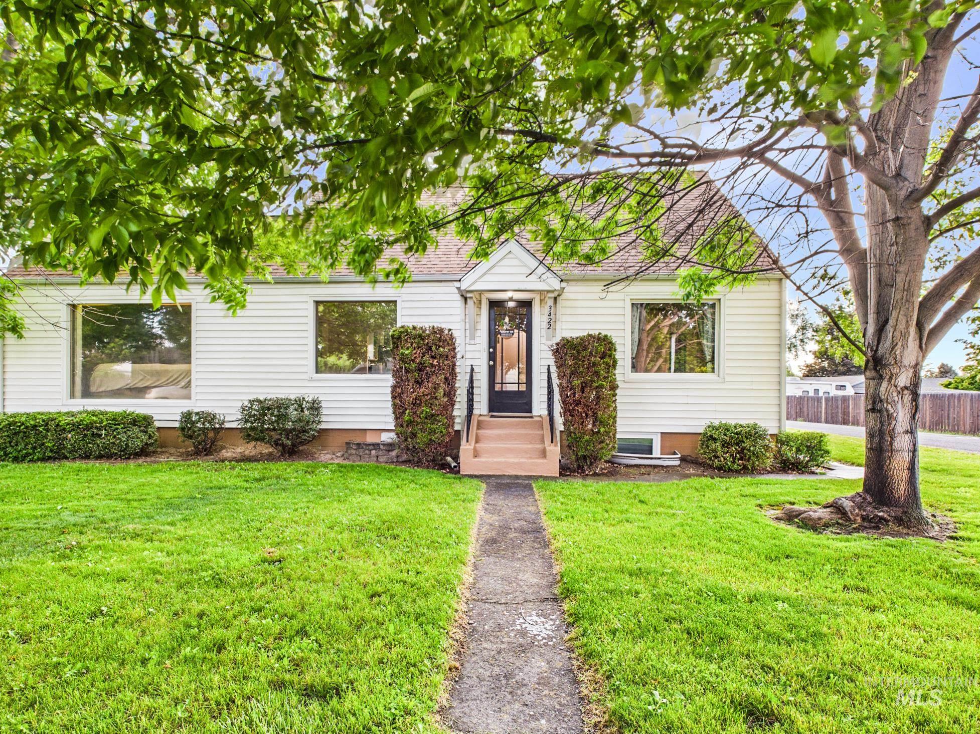 3422 6th Street Lewiston, ID 83501 - Photo 2 of 43 Charming white siding residence featuring a gabled roofline, front entry steps, large picture windows, and mature landscaping